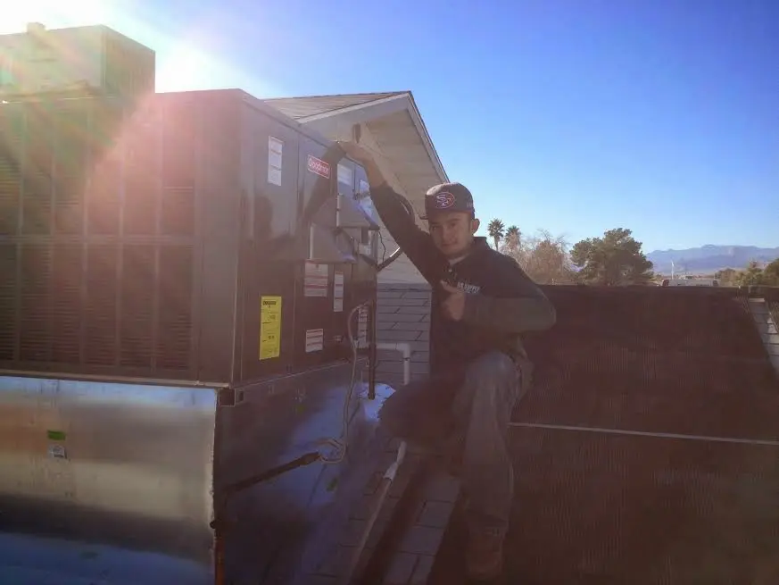 HVAC technician performing Air Duct Repair on a rooftop unit in Brentwood